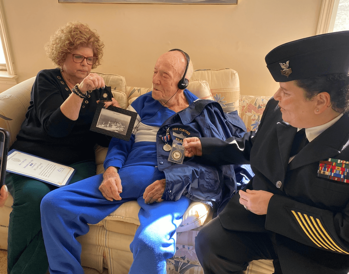 Spero team presenting medals and memorabilia to a WWII Navy veteran