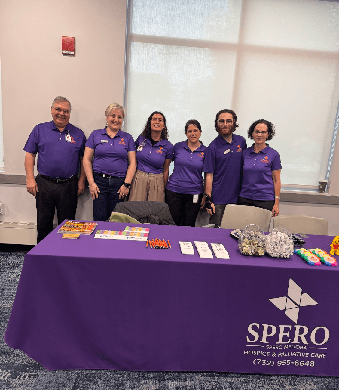 Spero Hospice team in purple polos at a community outreach booth